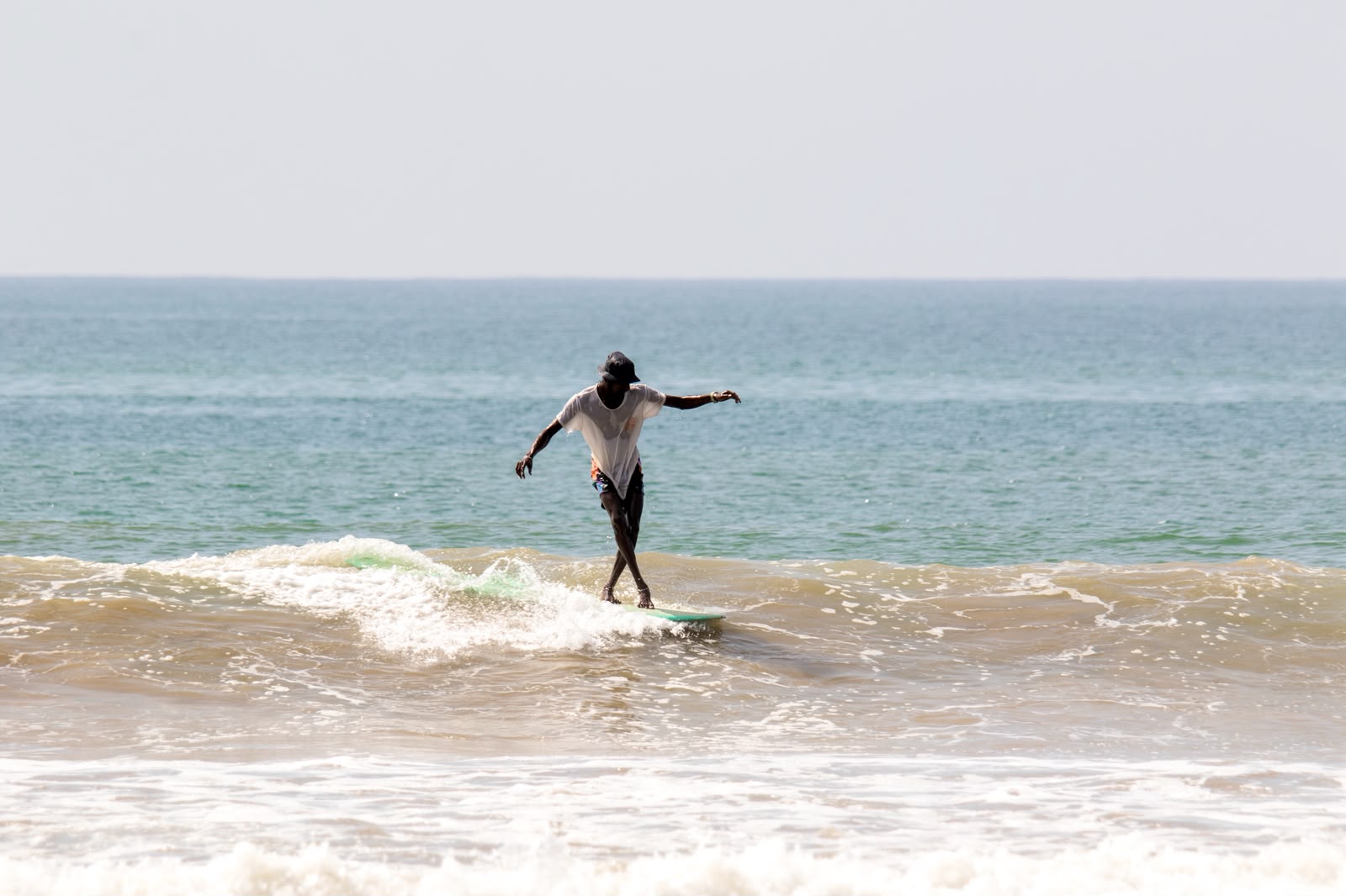 Achi longboarding on a small wave